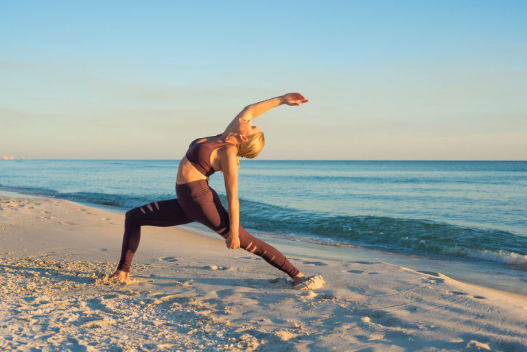 woman on beach dressed in yoga attire doing high lunge crescent variation, beach, yoga photography, yoga photographer, atlanta yoga photographer, atlanta photographer,